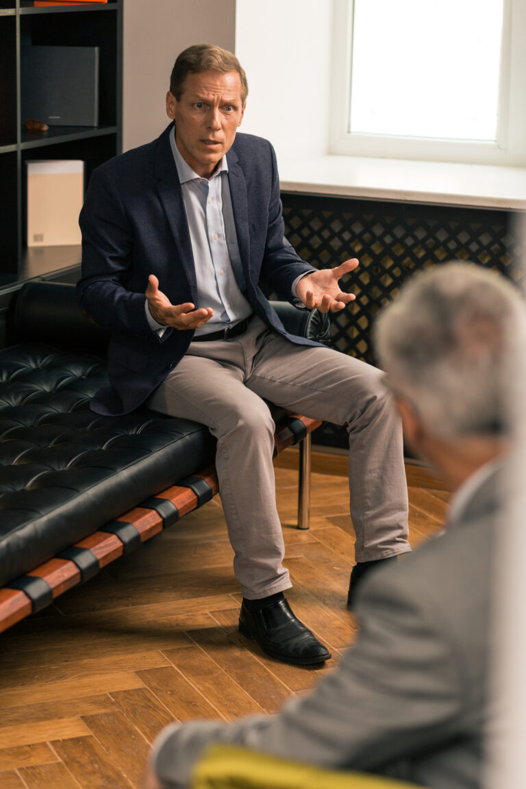 Indignant middle-aged Caucasian man sitting on the couch